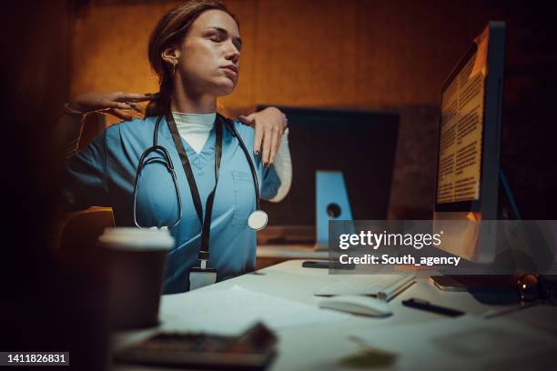 enfermera que trabaja hasta tarde - working overtime fotografías e imágenes de stock