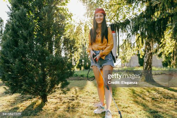 female farmer protecting his plants with chemicals - onkruidverdelger stockfoto's en -beelden