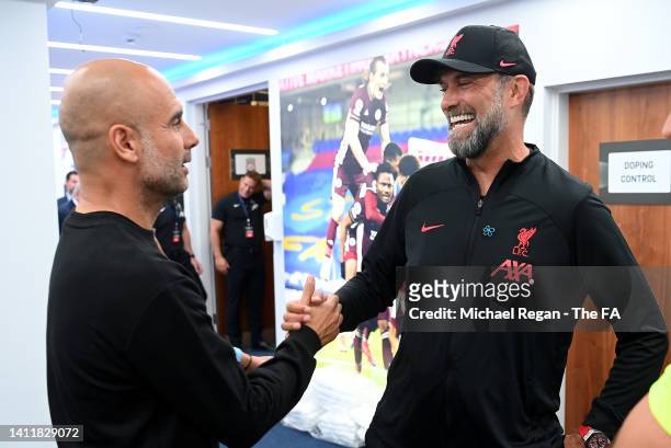 Pep Guardiola, Manager of Manchester City, shakes hands with Jurgen Klopp, Manager of Liverpool, as they meet Referee Craig Pawson prior to kick off...