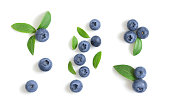 Set of blueberries isolated on white background. Blueberry berries with green leaves. Bilberry, huckleberry. Top view, flat lay.