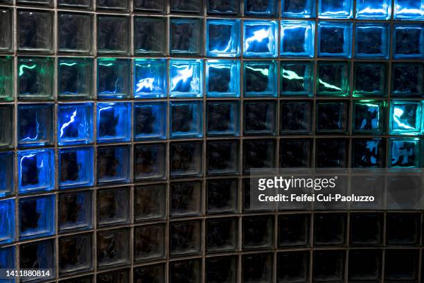 background of glass brick wall with blue and green light - glass cube fotografías e imágenes de stock