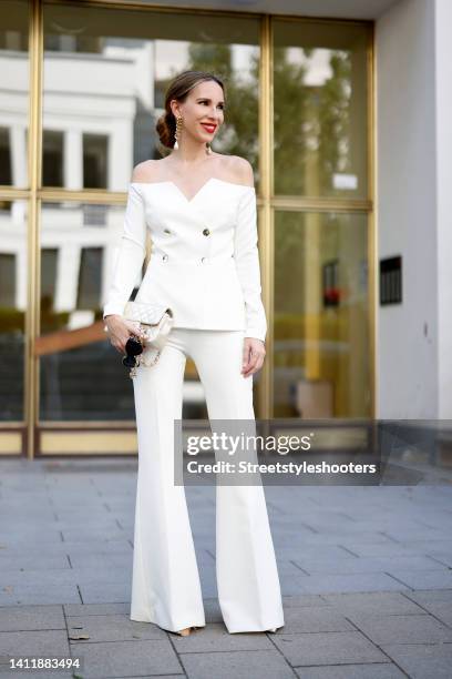 Alexandra Lapp wearing an ivory colored off the shoulder double-breasted blazer and matching wide leg pants by Safiyaa, vintage gold chain earrings...