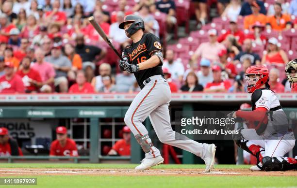 Trey Mancini of the Baltimore Orioles hits a single in the first inning against the Cincinnati Reds at Great American Ball Park on July 30, 2022 in...