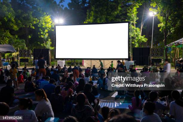 spectators at open-air cinema - projection screen night stock pictures, royalty-free photos & images