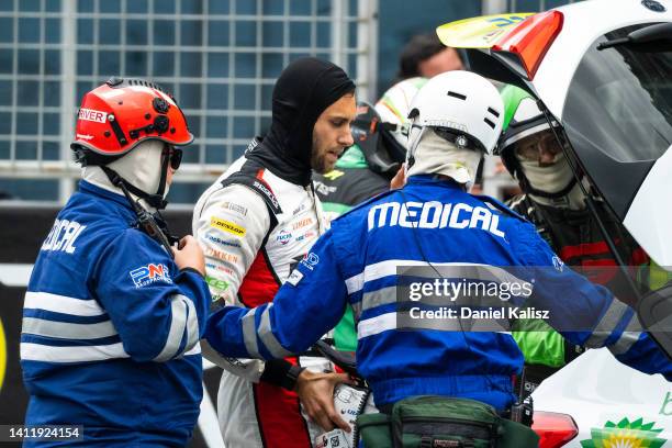 Andre Heimgartner driver of the Brad Jones Racing Holden Commodore ZB is attended to by medical staff after colliding with Thomas Randle driver of...