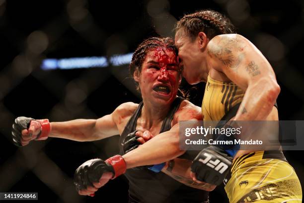 Julianna Pena exchanges strikes with Amanda Nunes of Brazil in their bantamweight title bout during UFC 277 at American Airlines Center on July 30,...