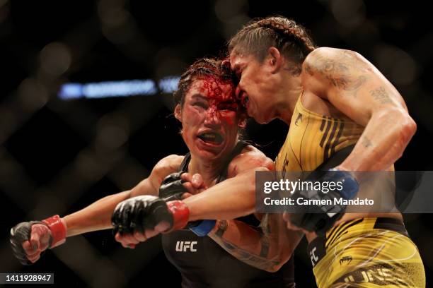 Julianna Pena exchanges strikes with Amanda Nunes of Brazil in their bantamweight title bout during UFC 277 at American Airlines Center on July 30,...