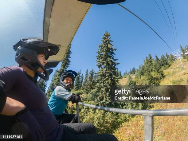 eurasian daughter, 55+ asian mother, riding chairlift, downhill mountain biking - ski lift summer stock pictures, royalty-free photos & images