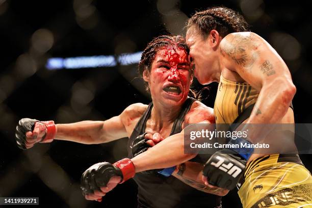 Amanda Nunes of Brazil exchanges strikes with Julianna Pena in their bantamweight title bout during UFC 277 at American Airlines Center on July 30,...