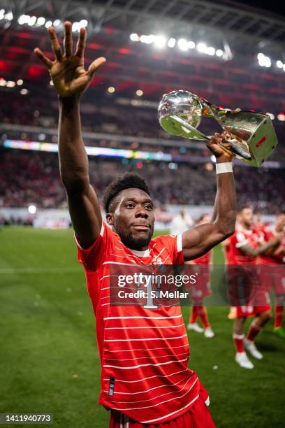 Alphonso Davies of FC Bayern Muenchen celebrates with the winners trophy after winning the Supercup 2022 match between RB Leipzig and FC Bayern...