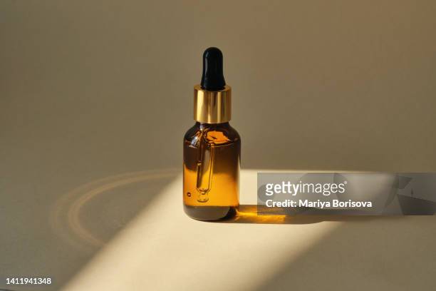a bottle of serum in the rays of the sun and beautiful highlights. - flacon compte gouttes photos et images de collection