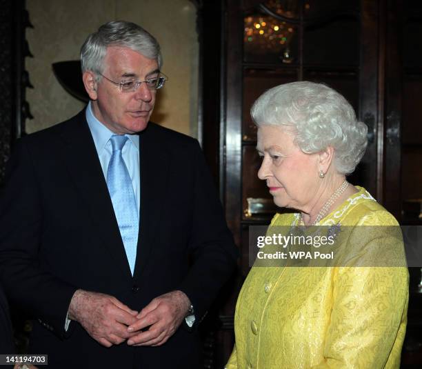 Queen Elizabeth II speaks with former Prime Minister John Major during a Commonwealth Day Reception at Marlborough House on March 12, 2012 in London,...