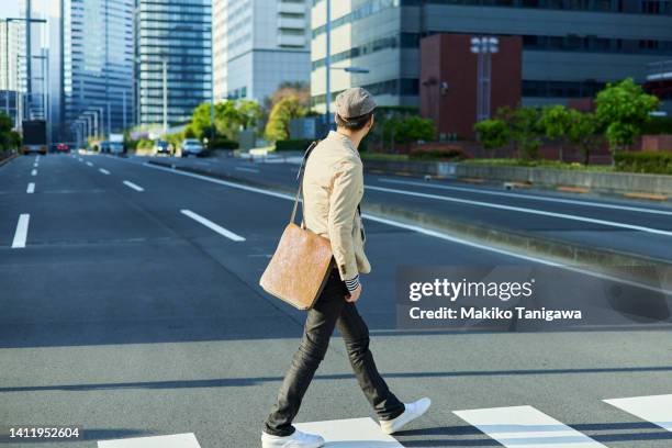 asian businessman crosses an urban pedestrian crossing - 後ろ姿　男性 ストックフォトと画像