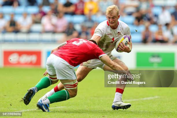Jamie Adamson of Team England is tackled by Morgan Sieniawski of Team Wales during the Men's 9-12 Semi- Final match between Team England and Team...