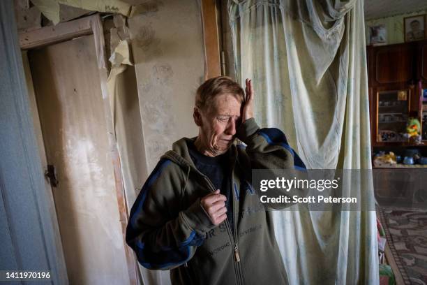 Ukrainian resident Nadia Vasilenko wipes away tears as she describes damage to her apartment from a Russian rocket that landed in early March, in the...