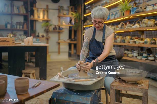 senior artist woman making clay bowl on pottery wheel. - old woman tattoos stock pictures, royalty-free photos & images