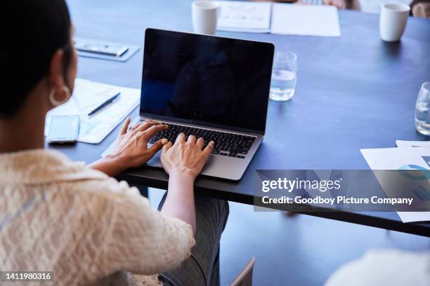 businesswoman working on a laptop during a boardroom meeting - over the shoulder view stock pictures, royalty-free photos & images
