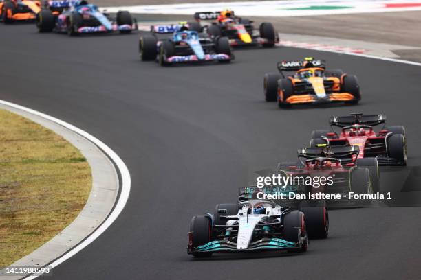 George Russell of Great Britain driving the Mercedes AMG Petronas F1 Team W13 leads Carlos Sainz of Spain driving the Ferrari F1-75 and the rest of...