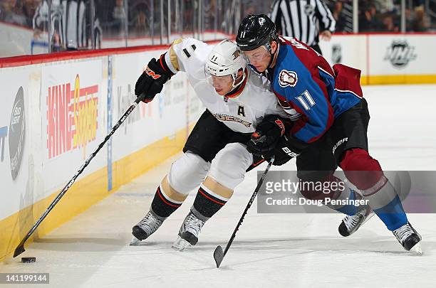 Saku Koivu of the Anaheim Ducks controls the puck while under pressure from Jamie McGinn of the Colorado Avalanche at the Pepsi Center on March 12,...