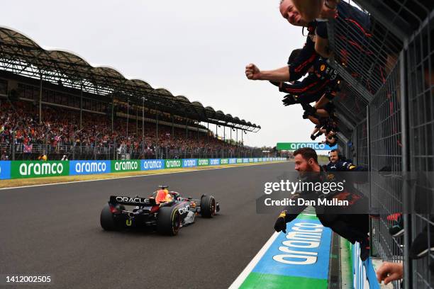 Race winner Max Verstappen of the Netherlands driving the Oracle Red Bull Racing RB18 passes his team celebrating on the pitwall during the F1 Grand...