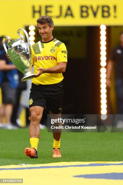 Karlheinz Riedle, former player carries the Cham,pions League trophy during the season opening of Borussia Dortmund at Signal Iduna Park on July 31,...