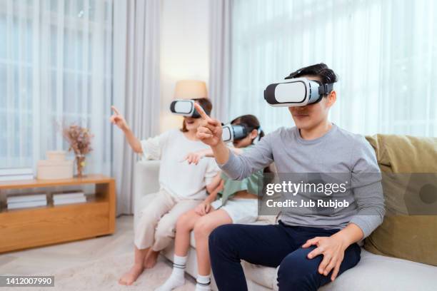 parents and daughters wearing virtual reality glasses play video games. - cardboard vr stock pictures, royalty-free photos & images