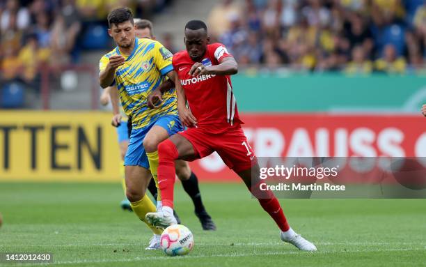 Jannis Nikolaou of Eintracht Braunschweig challenges Myziane Maolida of Hertha BSC during the DFB Cup first round match between Eintracht...