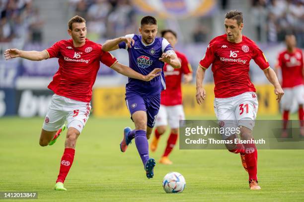 Dimitrij Nazarov of Aue in action with Maxim Leitsch and Dominik Kohr of Mainz during the DFB Cup first round match between Erzgebirge Aue and 1. FSV...