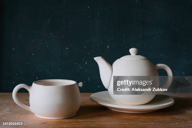 a mug with black, green or herbal tea, a ceramic teapot with warming tea, on a wooden table, in a stylish, modern cafe, restaurant or cafeteria. the concept of breakfasts, business meetings, dates. coffee break. - theepot stockfoto's en -beelden
