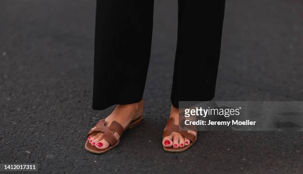 Leo Eberlin is seen wearing Hermes brown leather Oran sandals and Uniqlo black pants on July 28, 2022 in Berlin, Germany.
