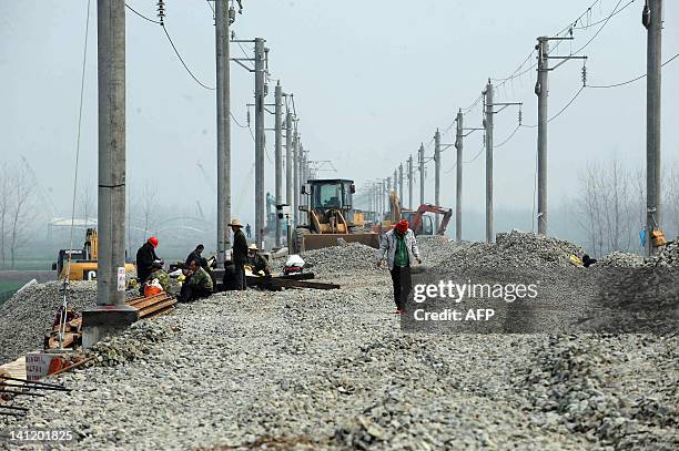 In a photograph taken on March 12 work continues along a section of a new high-speed railway near Qianjiang in central China's Hubei province, after...