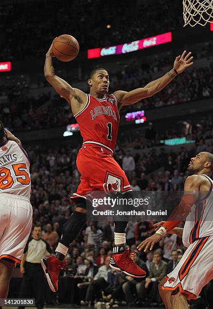 Derrick Rose of the Chicago Bulls goes up for a dunk between Baron Davis and Tyson Chandler of the New York Knicks on his way to a game-high 32...