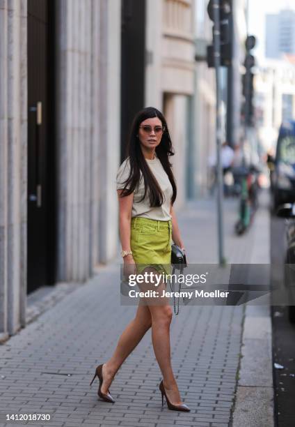 Leo Eberlin is seen wearing The Attico green mini skirt, an Uniqlo white shirt, COS brown shades, a Chanel grey mini bag and brown Christian...