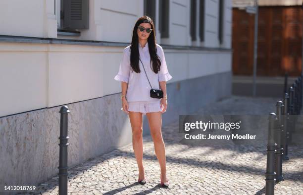 Leo Eberlin is seen wearing Sleeper lilac pastel mini shorts and Sleeper blouse, Chanel pink tweed heels, Chanel mini bag and & other stories shades...