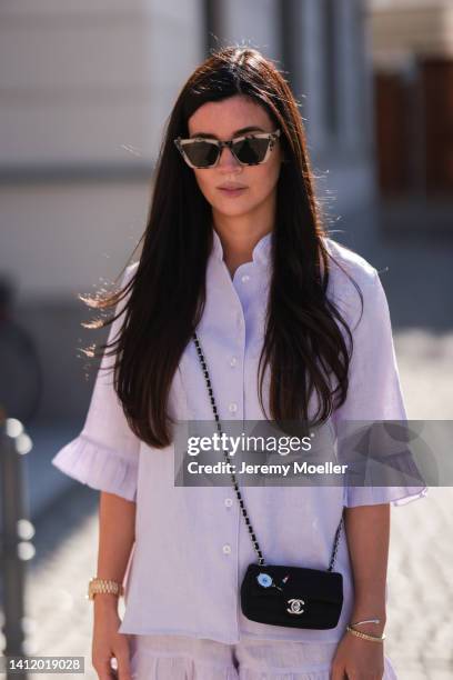 Leo Eberlin is seen wearing Sleeper lilac pastel mini shorts and Sleeper blouse, Chanel mini black bag and & other stories black shades and a golden...