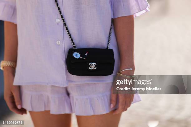 Leo Eberlin is seen wearing Sleeper lilac pastel mini shorts and Sleeper blouse, Chanel mini black bag and & other stories black shades and a golden...