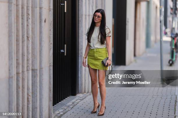 Leo Eberlin is seen wearing The Attico green mini skirt, an Uniqlo white shirt, COS brown shades, a Chanel grey mini bag and brown Christian...