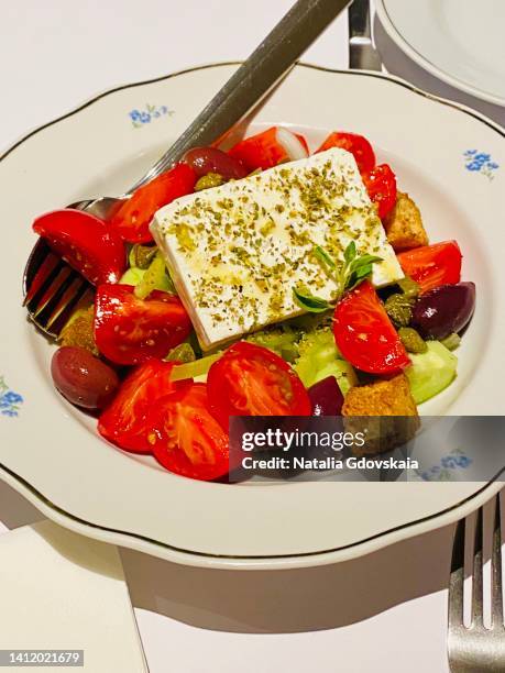 greek village salad horiatiki with feta cheese, olives, cherry tomato, cucumber and red onion, vegetarian mediterranean food, low calories dieting meal, side view. authentic image in cafe - greek salad stock pictures, royalty-free photos & images