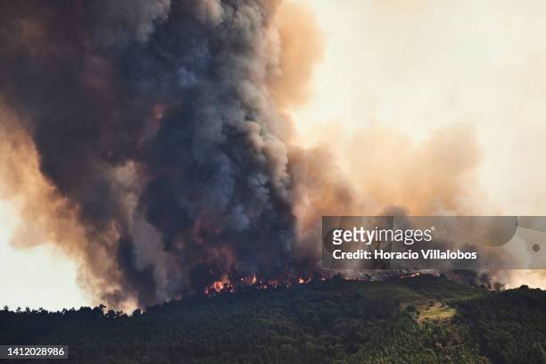 Large plume of smoke and flames are seen at a forest fire being fought by 321 firefighters, 84 vehicles and 9 specialized aircraft on July 31, 2022...