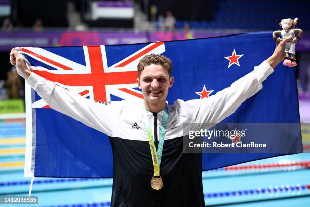 Gold medalist, Lewis Clareburt of Team New Zealand poses with their medal and their nations flag during the medal ceremony for the Men's 200m...