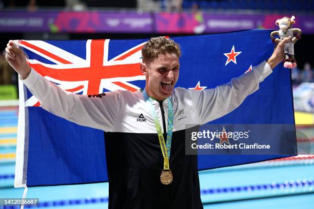 Gold medalist, Lewis Clareburt of Team New Zealand poses with their medal and their nations flag during the medal ceremony for the Men's 200m...