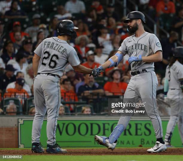 Jesse Winker of the Seattle Mariners shakes hands Adam Frazier after he hit a two run home run in the eighth inning against the Houston Astros at...