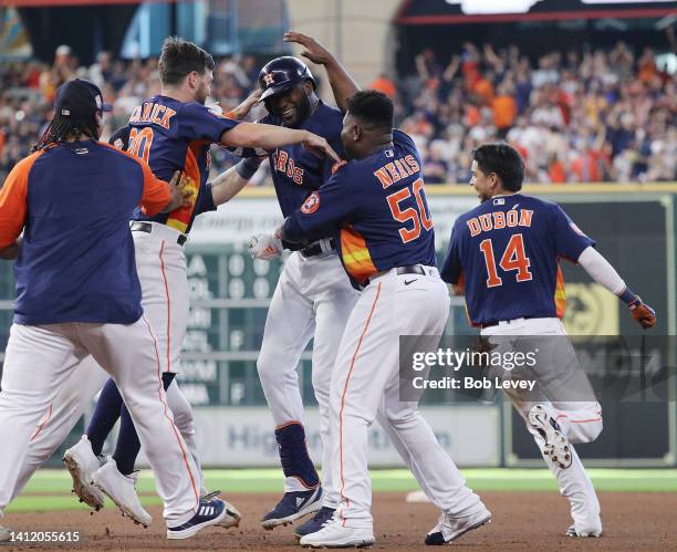 Yordan Alvarez of the Houston Astros, center, is congratulated by his teammates after a walk-off single in the tenth inning against the Seattle...