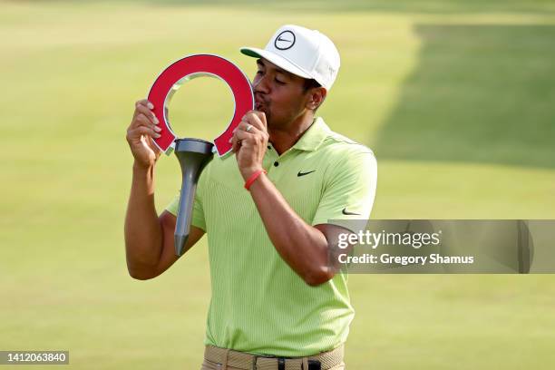 Tony Finau of the United States kisses the trophy after winning the Rocket Mortgage Classic at Detroit Golf Club on July 31, 2022 in Detroit,...