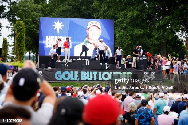 Henrik Stenson of Majesticks GC, winner of the individual trophy shakes hands with third place Team Captain Dustin Johnson of 4 Aces GC as second...