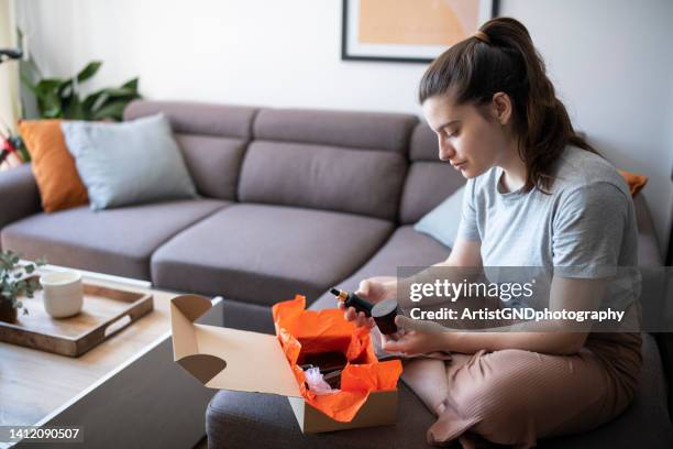 young woman opening box with beauty products. - subscription stockfoto's en -beelden