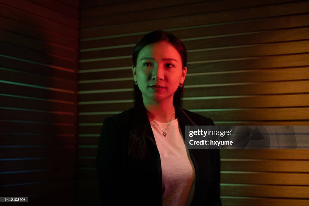 Potrait of an Asian Chinese businessman lit by coloured LED lighting