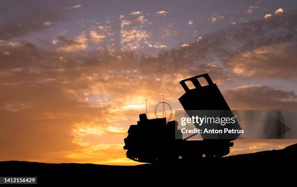 multiple launch rocket system on the background of sunset sky - weapon stock pictures, royalty-free photos & images