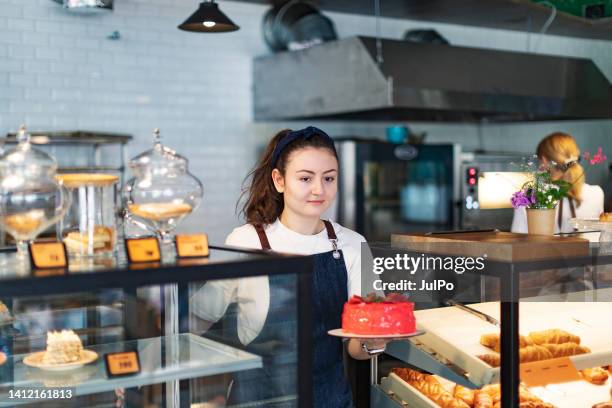 baker taking strawberry cake from store counter - pastry chef stock pictures, royalty-free photos & images