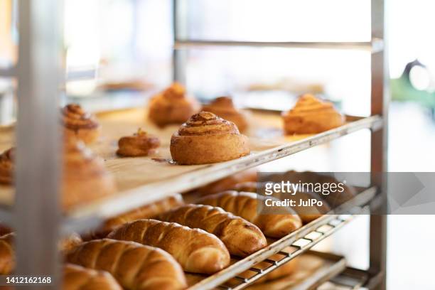 fresh french bread and croissants in a bakery in cooling rack - food and drink production stock pictures, royalty-free photos & images